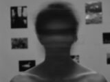 a blurry image of a man's face in front of a wall with