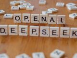 Close-up of wooden Scrabble tiles spelling OpenAI and DeepSeek on wooden table.