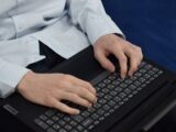 Person typing on a laptop keyboard
