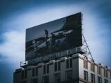 Billboard on top of a building against blue sky