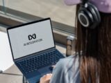 Person using laptop with ai integration logo displayed.