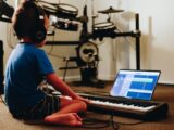 person in blue shirt playing piano