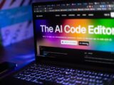 Laptop displays "the ai code editor" website.