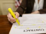 A close-up of a hand highlighting a contract, emphasizing important legal terms.