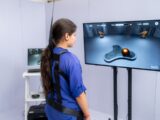 Woman wearing harness interacts with virtual reality game.