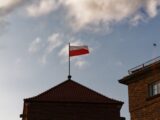 a red and white flag on top of a building
