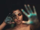 a woman with her hands painted blue and green