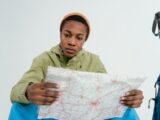 Teenage boy reading a map for travel adventure planning.