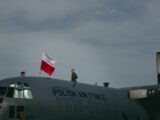 a man standing on top of a polish air force plane