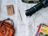 flat lay photography of camera, book, and bag