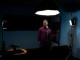a man standing in a room with a microphone