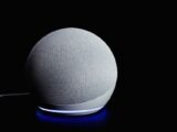 Modern smart speaker device with illuminated ring, featured on a dark background.