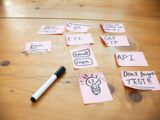 Sticky notes with words and drawings on wooden table.