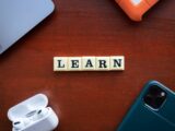 the word learn spelled with scrabble letters on a wooden table