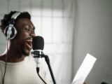 a man wearing headphones singing into a microphone