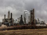 factories with smoke under cloudy sky
