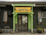 a green and yellow building with a sign on it