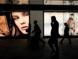 silhoutte of three persons near billboard