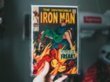 Vintage Iron Man comic book held by hand, showcasing iconic superhero imagery.